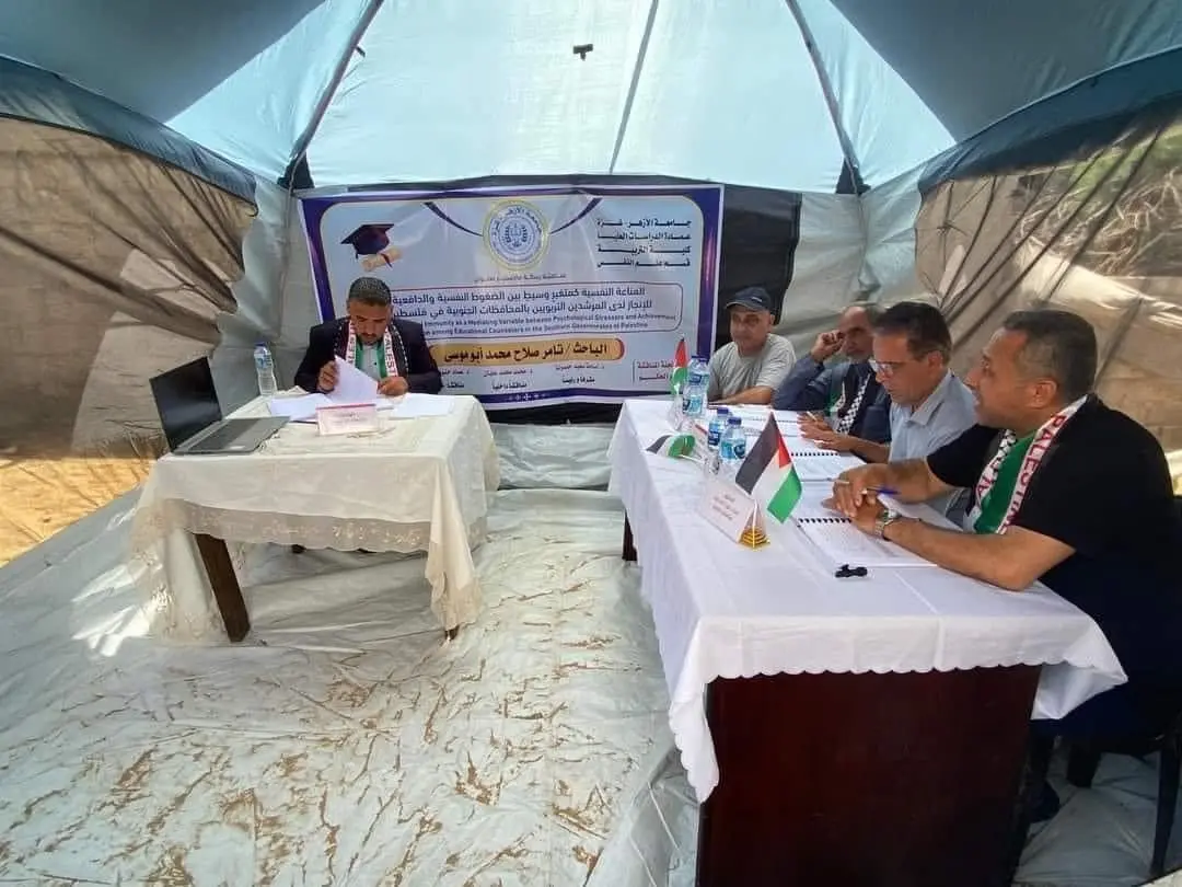 A student studying inside a tent